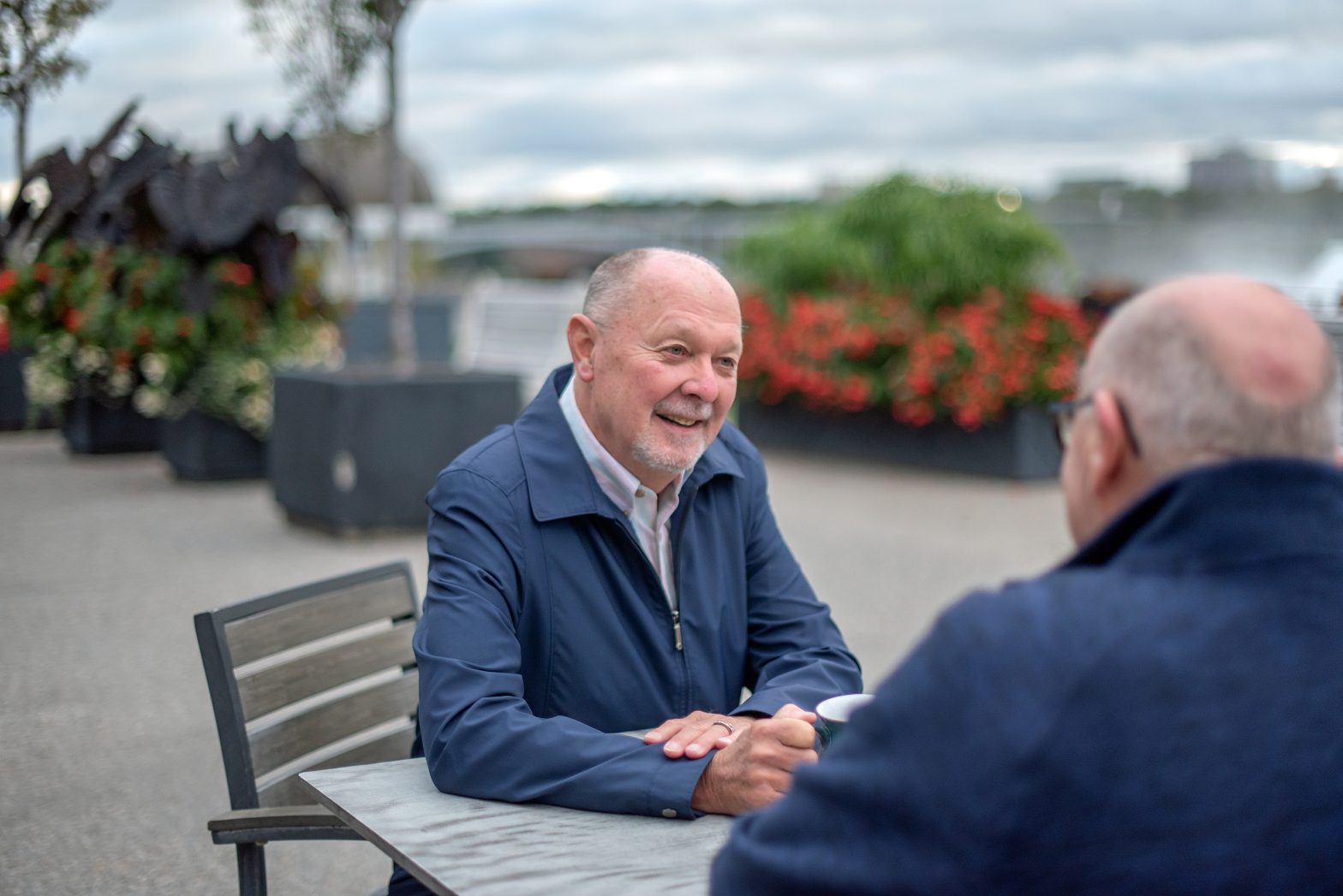 Senior gay couple sit at an outdoor cafe.